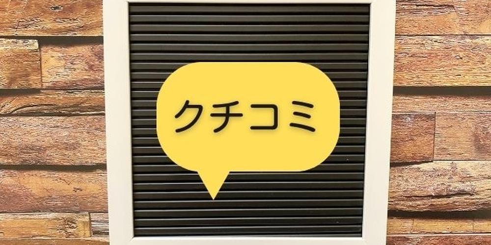 木目調の背景に飾られた黒いボードと白いフレーム、黄色の吹き出しに「クチコミ」と書かれたイメージ、レビューや評価を表現