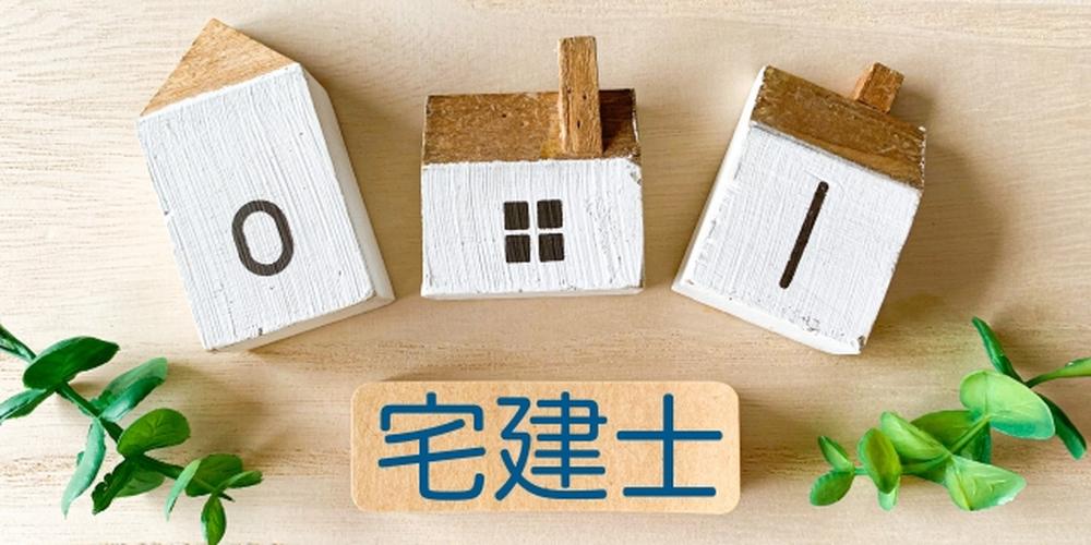 宅建士に関するイメージ。木製の家のミニチュアと「宅建士」の文字ブロックが並ぶナチュラルな背景の写真。