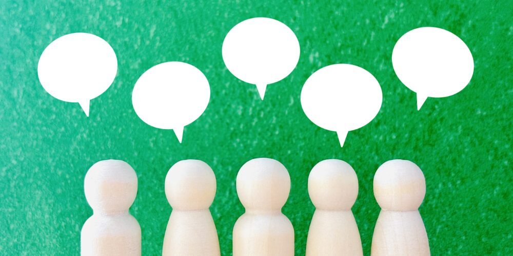 木製ピン人形と吹き出しで表した口コミイメージ