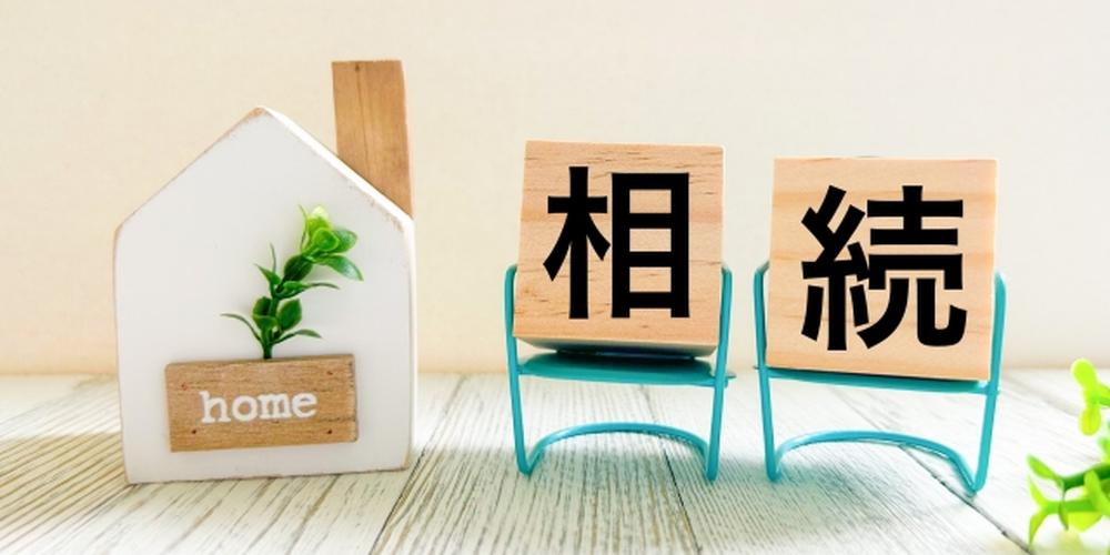 家と「相続」と書かれた木製ブロックが並ぶ、相続に関するイメージ写真