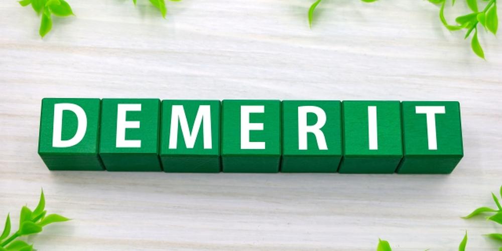 「DEMERIT」の文字が並ぶ緑のブロックと白木調の背景、デメリットや短所を示すイメージ