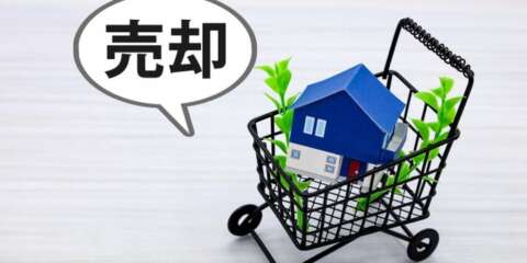 売却と書かれた吹き出しと、家の模型が入ったショッピングカートの写真。不動産の売却イメージ